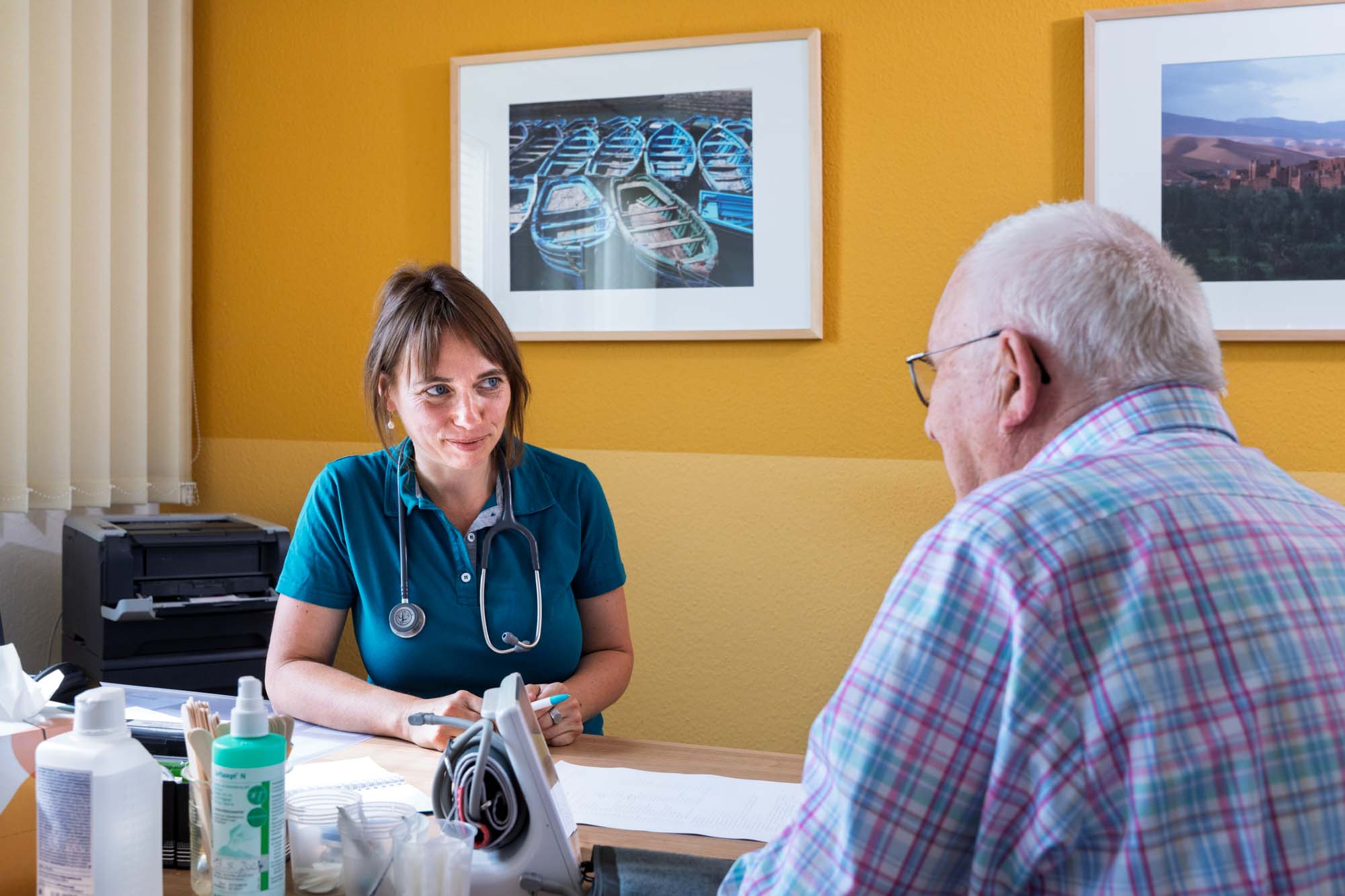 Frau Dr. Rieprecht sitzt im Gespräch mit einem Patienten in ihrem Sprechzimmer