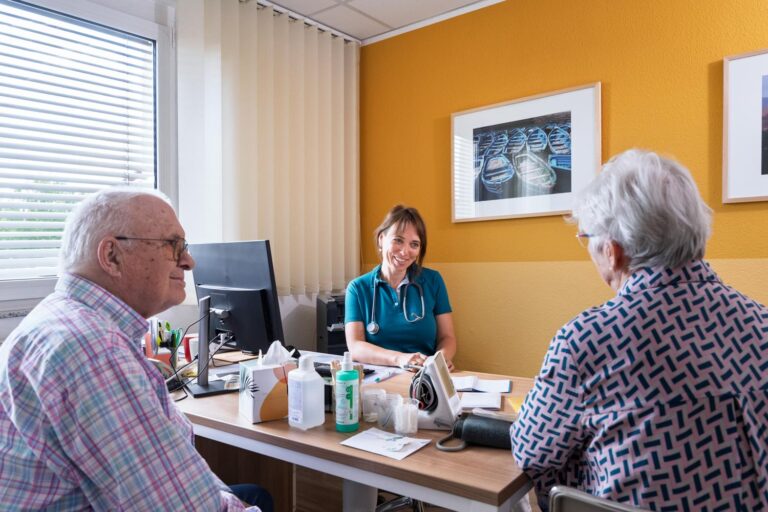 Dr. med. Annette Rieprecht im Sprechzimmer sitzend im Gespräch mit Patientin und Angehörigem